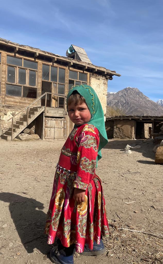 A girl wearing a colourful dress in Nuristan